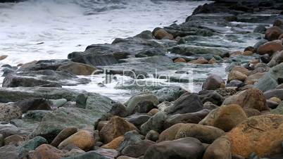 storm waves crash against the rocks