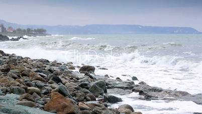 storm waves crash against the rocks