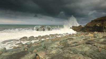 storm waves crash against the rocks