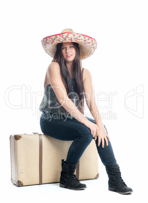 Mädchen mit Sombrero sitzt auf Koffer