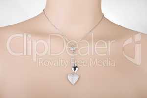 Silver necklace with two heart pendants on a mannequin