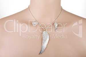 Silver necklace with angel wing and heart on a mannequin