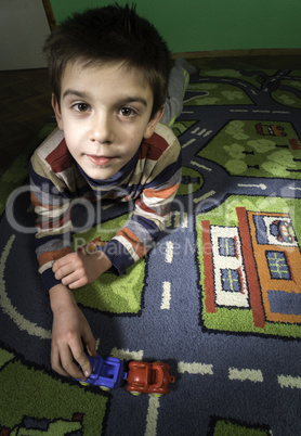 child is playing with cars