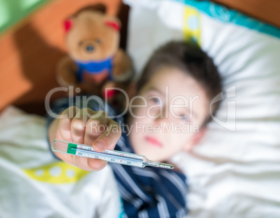 sick child in bed with teddy bear