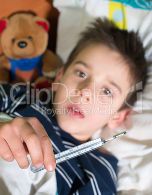 sick child in bed with teddy bear