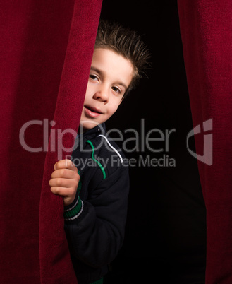 child appearing beneath the curtain