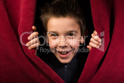 child appearing beneath the curtain