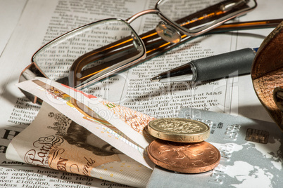 glasses, coins, credit cards and banknotes on newspaper