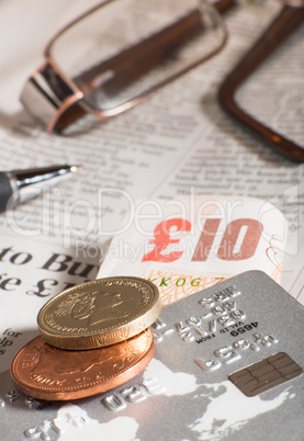 glasses, coins, credit cards and banknotes on newspaper
