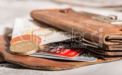 coins, credit cards and british pounds on newspaper