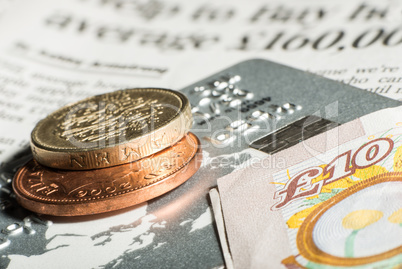 coins, credit cards and banknotes on newspaper.