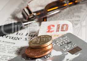 glasses, coins, credit cards and banknotes on newspaper
