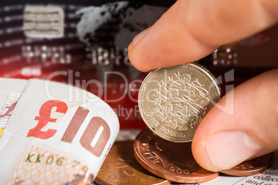 coins, credit cards and british pounds on newspaper