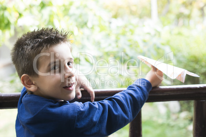 kid throws paper plane