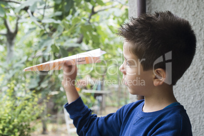 kid throws paper plane