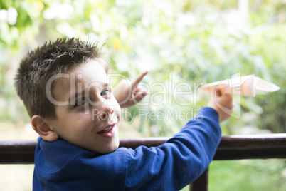 kid throws paper plane