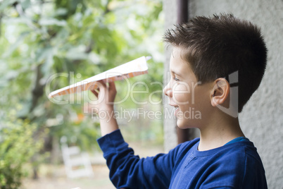 kid throws paper plane