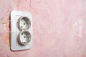 white socket on pink wall