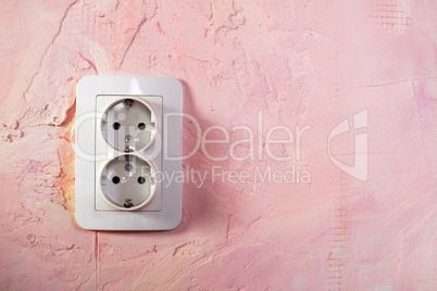 white socket on pink wall