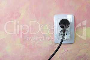 white socket and cable on pink wall.