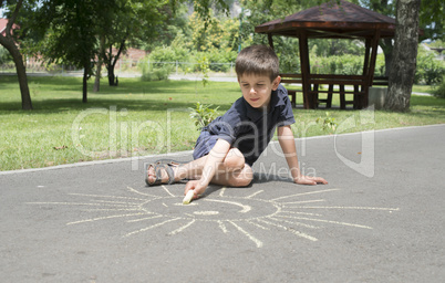 child drawing on asphalt