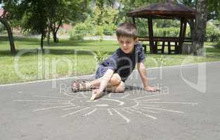 child drawing on asphalt