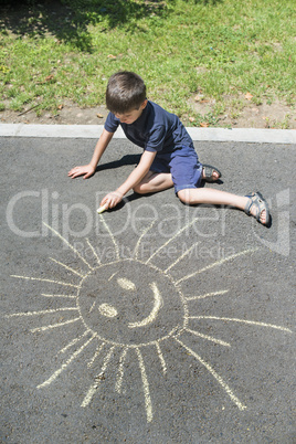 child drawing on asphalt