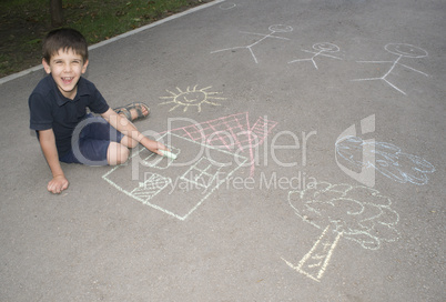 child drawing sun and house on asphal