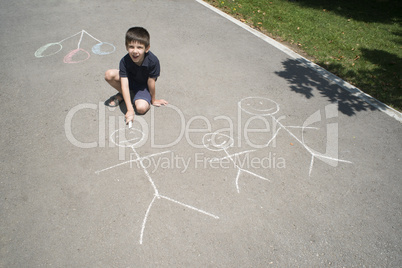 child drawing family on asphalt