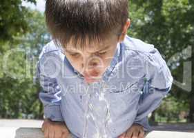 child drinking water from a fountain