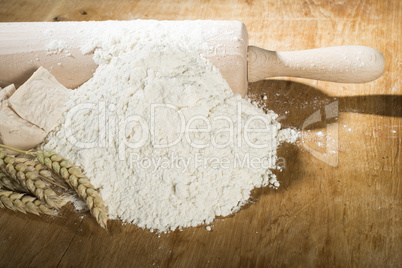 pile of flour, rolling pin and wheat