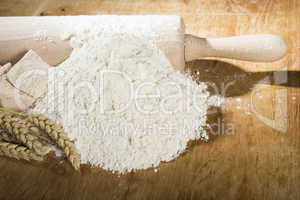 pile of flour, rolling pin and wheat