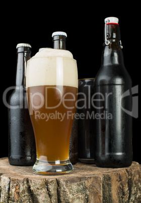 bottles of beer and beer mug on stump