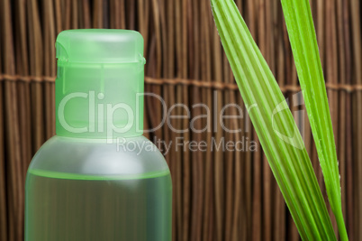 green cosmetic bottle and leaf