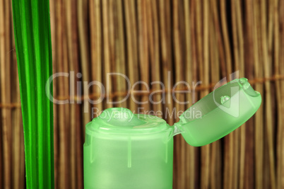 green cosmetic bottle and leaf