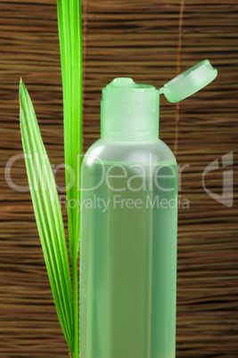 green cosmetic bottle and leaf