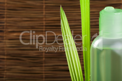 green cosmetic bottle and leaf