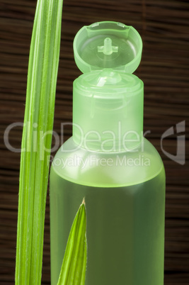 green cosmetic bottle and leaf