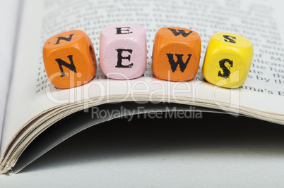 word news.wooden cubes on magazine
