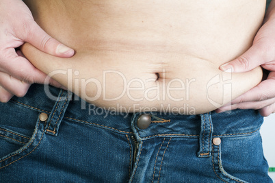 woman pinching fat from her abdomen