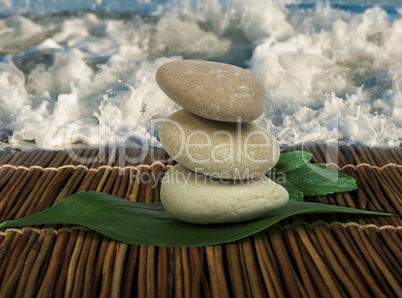 stacked stones on wooden base for spa and green leafs