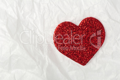 shiny red heart on white paper