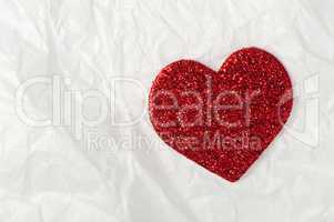 shiny red heart on white paper