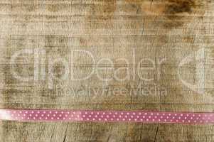 pink ribbon for gift wrap on wooden background