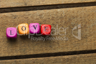 word love on multicolored wooden cubes on wood