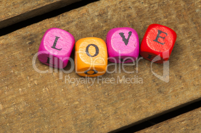 word love on multicolored wooden cubes on wood