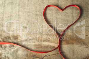 red ribbon heart on wooden background