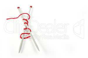 knitting skewers and red yarn