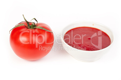 tomato and bowl of tomato sauce