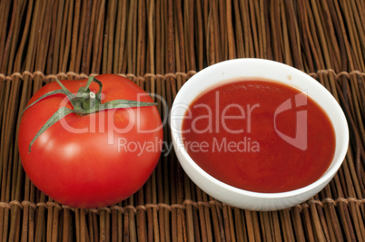 tomato and bowl of tomato sauce
